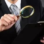 Inspecting a document with a magnifying glass: ID 77509910 © Andrey Popov | Dreamstime.com