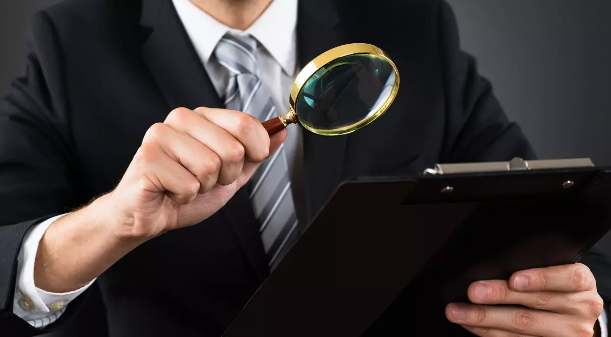 Inspecting a document with a magnifying glass: ID 77509910 © Andrey Popov | Dreamstime.com