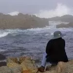 Woman in hat overlooking a rainy sea, photo credit: Pixnio