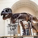 Sue the T.rex holding a 'sign' saying Trust Us, but we won't tell you why you should, adapted from: ID 27396520 © Cmlndm | Dreamstime.com