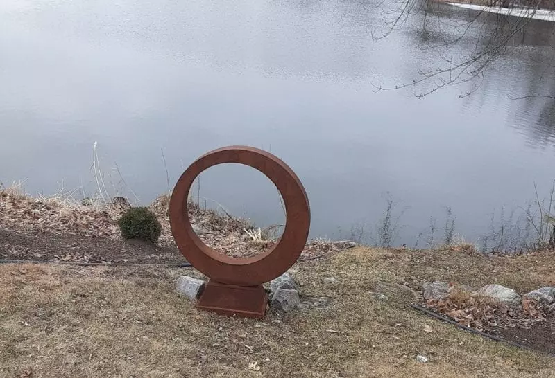 Zero shaped sculpture standing near a pond's edge, photo credit: Jeffry Stueber