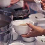 Hands passing out bowls of soup to the homeless: Photo 118467980 / Feeding Homeless © Todsaporn Bunmuen | Dreamstime.com