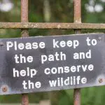 Please keep to the path sign on a rusty fence: Photo 97411565 © Richard Stemp | Dreamstime.com
