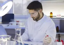 Scientist in lab reading from clipboard: Photo 220886653 © Lacheev | Dreamstime.com