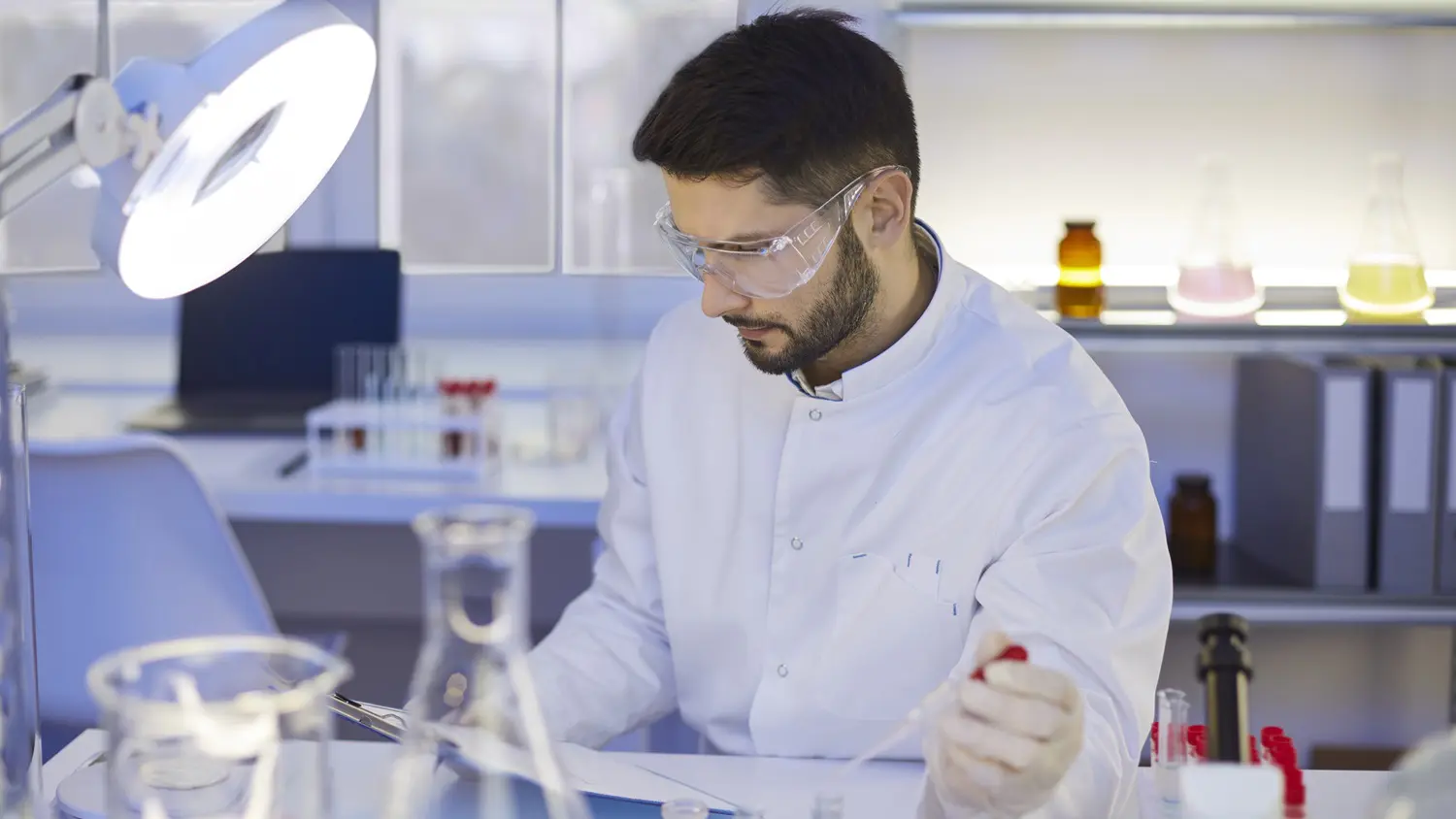 Scientist in lab reading from clipboard: Photo 220886653 © Lacheev | Dreamstime.com