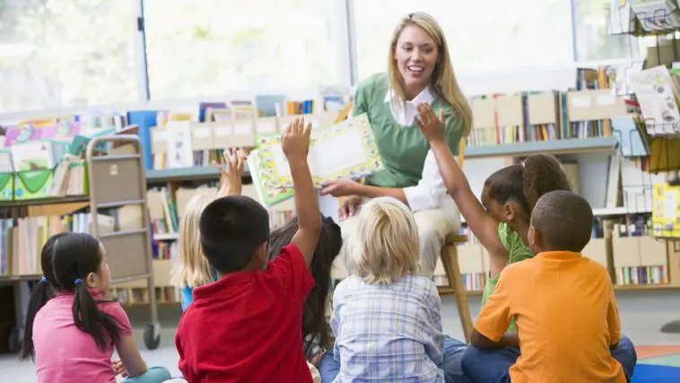 Kindergarten teacher reading a library book: Photo 6081708 | Children Library © Monkey Business Images | Dreamstime.com