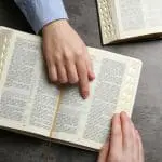 Bibles with hand pointing to a text: ID 241336418 © Chernetskaya | Dreamstime.com