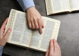 Bibles with hand pointing to a text: ID 241336418 © Chernetskaya | Dreamstime.com