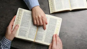 Bibles with hand pointing to a text: ID 241336418 © Chernetskaya | Dreamstime.com