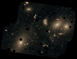 This deep image of the Virgo Cluster obtained by Chris Mihos and his colleagues using the Burrell Schmidt telescope shows the diffuse light between the galaxies belonging to the cluster. North is up, east to the left. The dark spots indicate where bright foreground stars were removed from the image. Messier 87 is the largest galaxy in the picture (lower left).