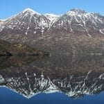 Snow dusted mountains with lake reflections