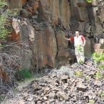 Lava rock face with a man showing scale, photo credit: Ian Juby