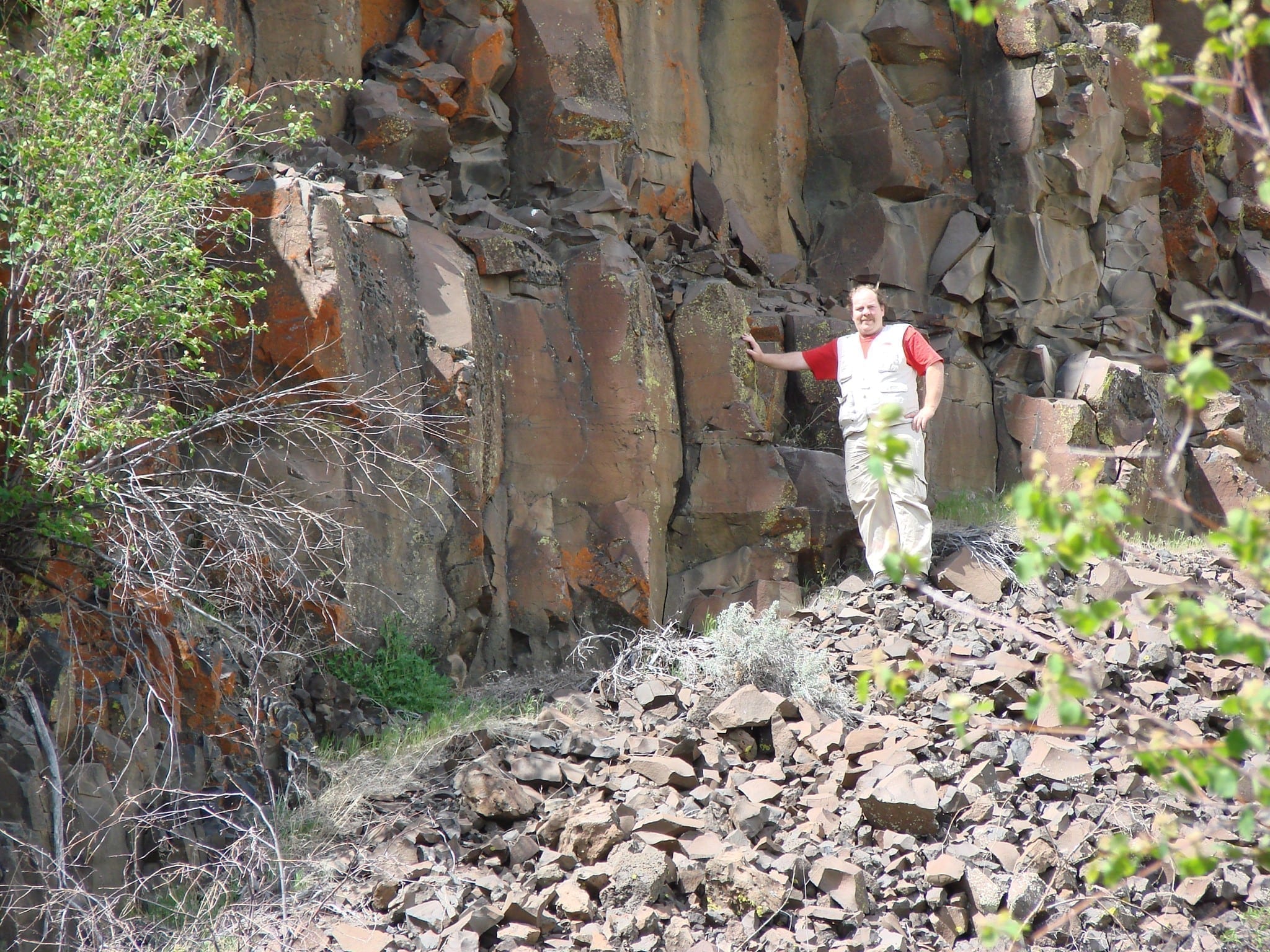 Lava rock face with a man showing scale, photo credit: Ian Juby