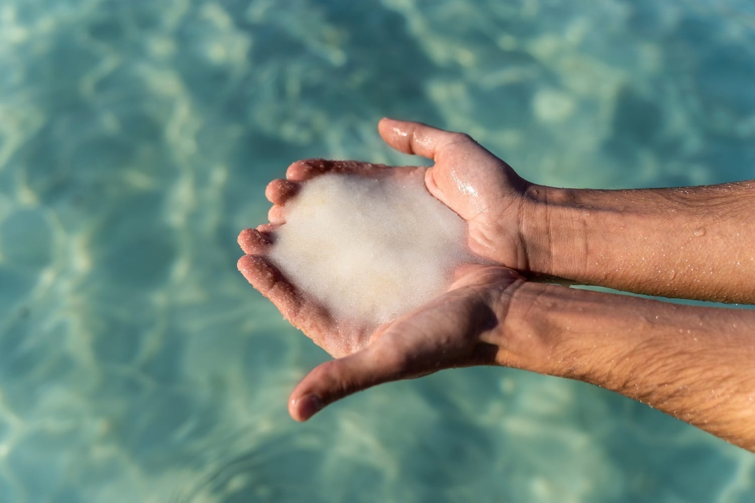 salt scooped up from the Dead Sea in a man's hands: ID 148173764 © NDStock | Dreamstime.com