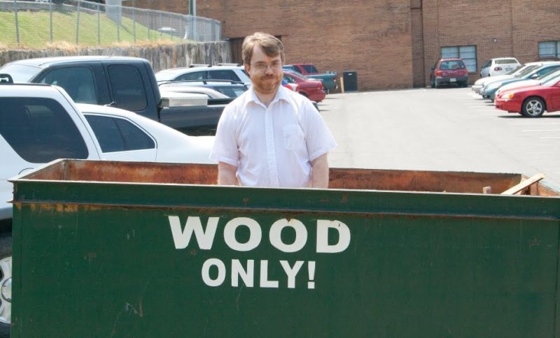 Todd Wood in a dumpster marked "Wood only!"